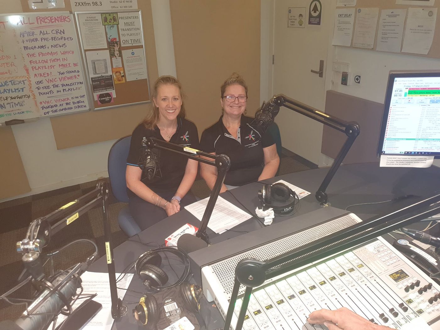 Beth and Shara in YWCSG polos in the 2XX FM radio studio
